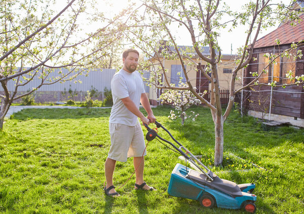 low angle view of young man mowing lawn