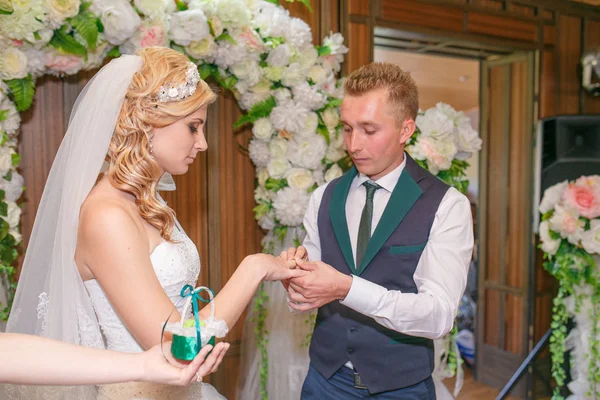 Portrait of handsome groom putting wedding ring on brides hand — Stock Photo, Image