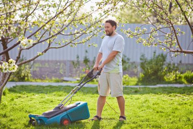 genç adamın çim biçme düşük açılı görünüş