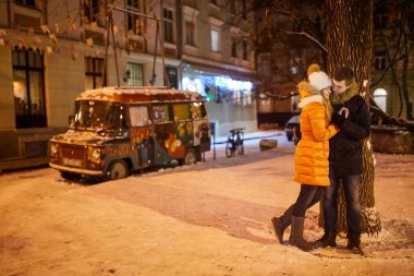 Genç çift Kış açık havada Noel alışveriş yaparken öpüşme.