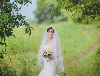 Şık gelin ve damat düğün günü dışarıda birlikte poz veriyorlar.