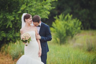 Gelin ve damat, düğün günü açık havada yürüyüş Doğa bahar. mutlu yeni evli kadın ve erkek yeşil park kucaklayan gelin çift. sevgi dolu evlilik çift açık.