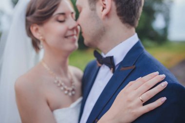 Şık gelin ve damat düğün günü dışarıda birlikte poz veriyorlar.