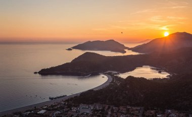 Ölüdeniz manzara güzel günbatımı lagoon Beach, Türkiye'nin deniz görünümünde. Şehir ışıkları ile plaj ve dağ olduğunu en iyi turistik hedef Fethiye.