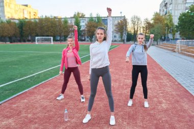 Pozitif kadın spor egzersizleri yapıyor... Üç güzel genç kadın spor güneşli bir günde parkta yapıyor grubu.