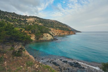 Taş ve kayalar ön planda kremsi sörf ve polis plajında akan, Kıbrıs.