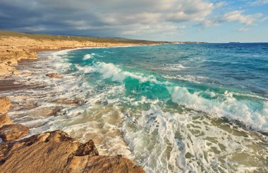 Açık turkuaz su ve dalgalar ile güzel vahşi kumsal.