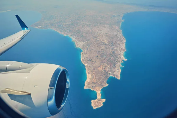 Plane is flying over the island of Cyprus. Airplane wing in flight from window. — Stock Photo, Image