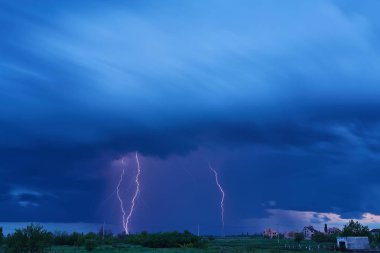 Massive colorful cloud to ground crazy skies lightning bolts hitting the horizon clipart