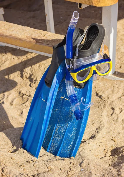 Strandurlaub Spaß Schnorchelausrüstung mit Ozeanwellen plätscherndes Wasser. Tauchen und Schnorcheln. Blaue Flossen, rosa Maske, Schnorchel auf sandigem Hintergrund. — Stockfoto