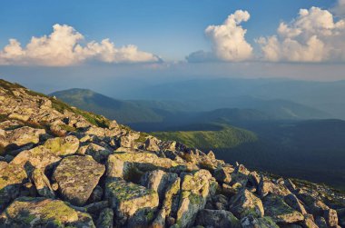 Dağlardaki yaz manzarası ve bulutlu koyu mavi gökyüzü.