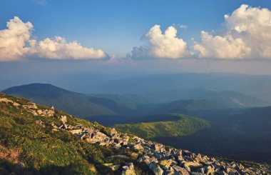 Dağlardaki yaz manzarası ve bulutlu koyu mavi gökyüzü.