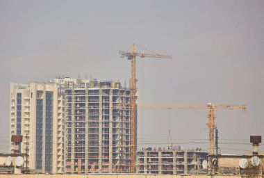 bitmemiş bina inşaat ve açık mavi gökyüzü arka plan karşı Vinçler bina