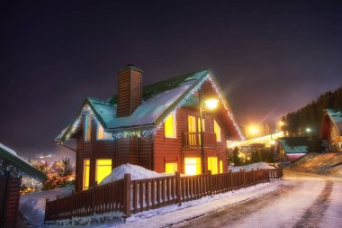 Hafif bir çelenkle süslenmiş bir kır evi. Kışın vahşi doğadaki kır evi..