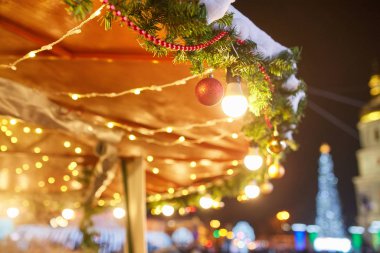 Sokakta süslenmiş Noel ağacı Toplar, oyuncaklar, lambalar ve çelenkler