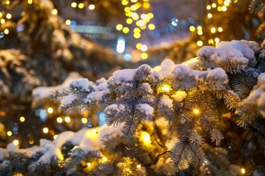 Sokakta süslenmiş Noel ağacı Toplar, oyuncaklar, lambalar ve çelenkler