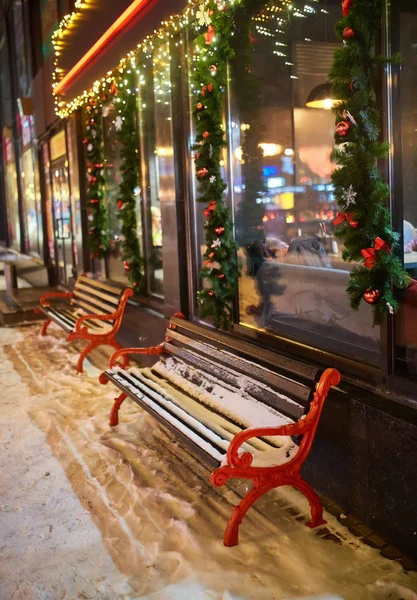 View of bench and shining lantern through snowing. — Stock Photo, Image