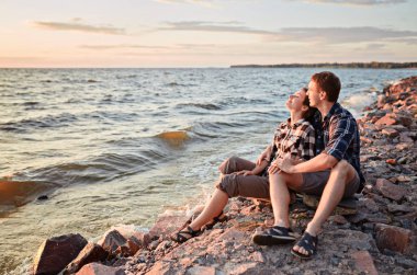 Göldeki aşıklar. Birbirine aşık genç bir çift, parkın kenarında, suyun kenarında oturuyor.