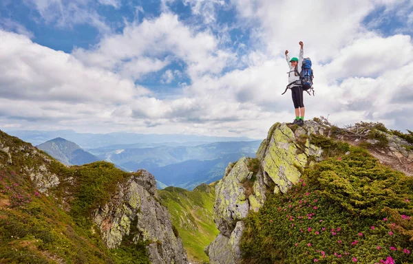 Jovem mulher mochileiro braços abertos no pico da montanha — Fotografia de Stock