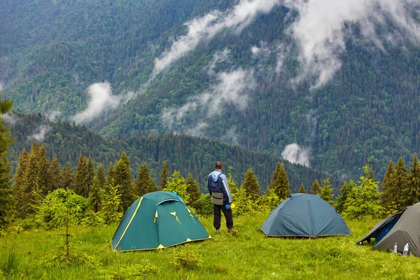 Caminante de pie cerca de la tienda de campaña en las montañas de los Cárpatos. Turista disfrutar de vista montaña . — Foto de Stock