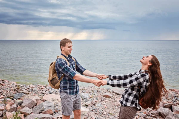 Пара туристов целуются на берегу озера — стоковое фото
