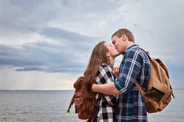 Пара туристов целуются на берегу озера — стоковое фото