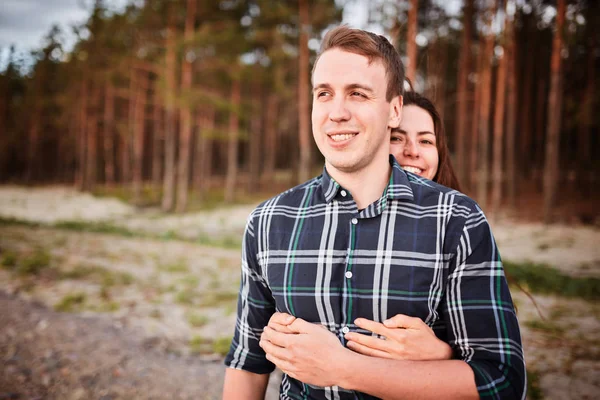 看着对方笑在一个浪漫的约会期间在森林里的年轻夫妇 — 图库照片