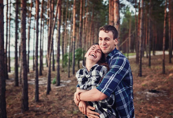 Mladý pár, usmívající se na sebe během romantické rande v lese — Stock fotografie
