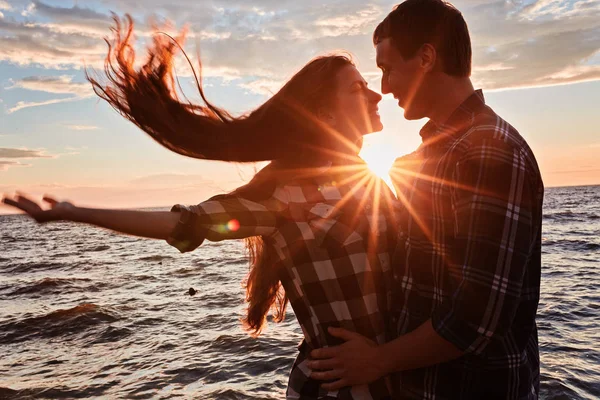 Пара в любви обратно легкий силуэт на закате озера — стоковое фото