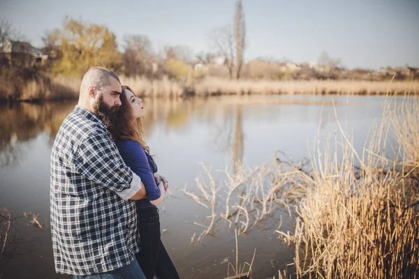 Young and stylish couple standing near water in park — 스톡 사진