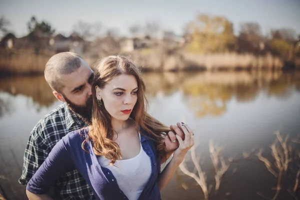 Ung och elegant par står nära vatten i parken — Stockfoto