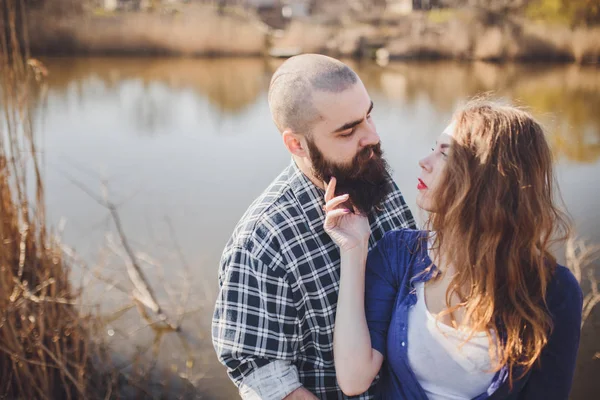 Joven y elegante pareja de pie cerca del agua en el parque — Foto de Stock