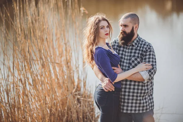 Joven y elegante pareja de pie cerca del agua en el parque — Foto de Stock