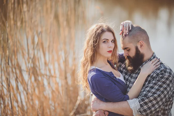 Young and stylish couple standing near water in park — Stock Photo, Image