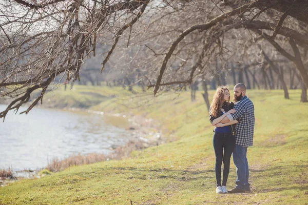 Dziewczyna i facet spacerują po parku. Portret pary, historia miłosna.Szczęśliwa, uśmiechnięta, kochająca się para razem rozciągnięta na pięknej przyrodzie. — Zdjęcie stockowe