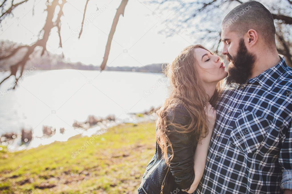 A girl and a guy are walking in the park. Portrait of a couple, a love story.Happy smiling, loving couple together outstretched at beautiful nature.