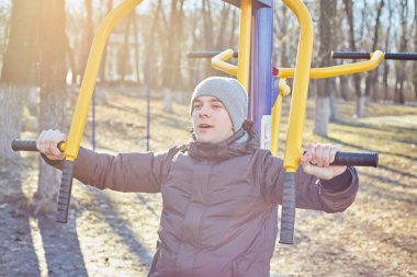 Adam parkta bir spor simülatörü yle meşgul.