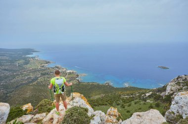 Dağın tepesindeki turist, körfeze bakan deniz manzaralı..