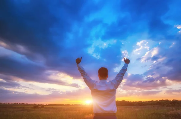 Happy businessman, standing in field over wind background with his hands up and thumbs up — Stock Photo, Image