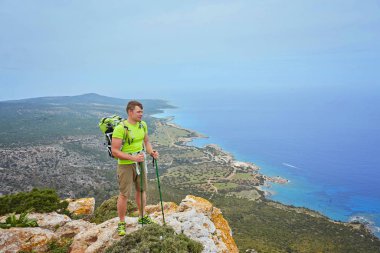 Dağın tepesindeki turist, körfeze bakan deniz manzaralı..