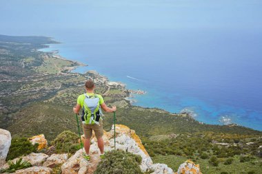 Dağın tepesindeki turist, körfeze bakan deniz manzaralı..