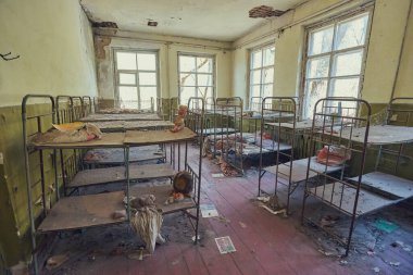 Pripyat, Ukrayna - 25 Nisan 2019: Terk edilmiş anaokulundaki boş metal yatak çerçeveleriyle dolu