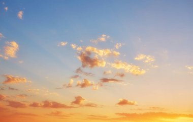 Bulutlar, ışık ışınları ve diğer atmosferik etkilerle gün batımı.