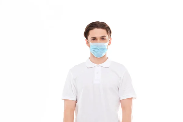 Un hombre con una camiseta blanca de apariencia europea con una máscara médica. Protección contra el virus Covid 19 . — Foto de Stock