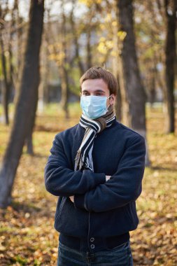 Tek kullanımlık tıbbi maskeli bir gencin yakın plan portresi. Salgın. Coronavirus. Karantinaya alın. Maskeli genç adam. Covid 19. Tıp maskeli bir öğrenci..