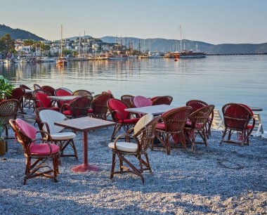 Türkiye 'nin Bodrum kentindeki sahil restoranının kumsalında şirin sandalyeler ve masa