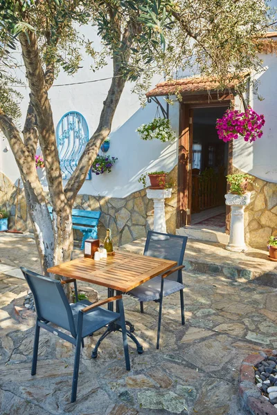 希腊Cyclades岛上白色墙壁上的希腊蓝色窗户 上面有咖啡桌和椅子的经典景象 — 图库照片
