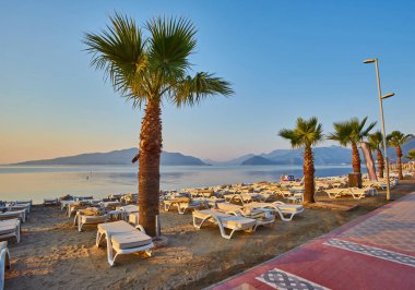 İnsansız kumsal ve güneş pansiyonları, şemsiyeler, palmiye ağaçları, Marmaris, Türkiye,