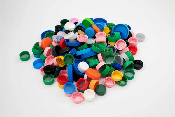 A pile of colourful plastic bottle caps isolated on white background