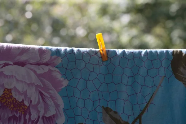 Une pince à linge sur drap de lit bleu — Photo